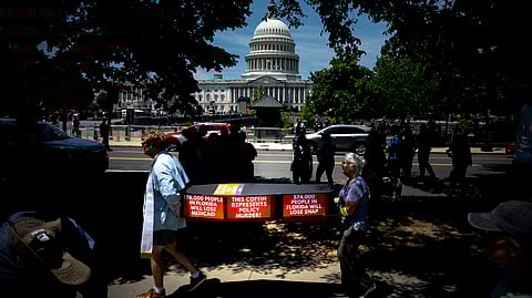 Demonstrators carry cardboard caskets in front of the US Capitol in protest of US President Donald Trump's tax breaks and spending cuts package, Monday, June 30, 2025, in Washington.
