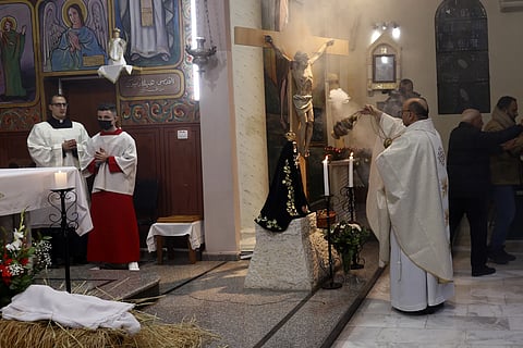 Fr. Gabriele Romanelli, Latin parish priest of Gaza Strip, left, prays during the midnight Christmas Eve mass at Deir AI Latin Holy Family Catholic Church in Gaza City, Dec 4, 2021.