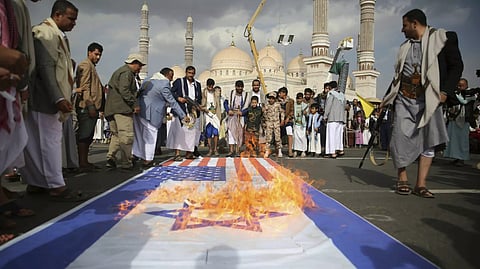 Houthi supporters burn US and Israeli flags during an anti-US and anti-Israel weekly rally in Sanaa, Yemen, Friday, June 20, 2025.