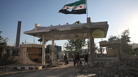 Security members carry belongings as they leave the damaged Syrian Defense Ministry building allegedly hit by several Israeli airstrikes, in Damascus, Syria, Wednesday, July 16, 2025.