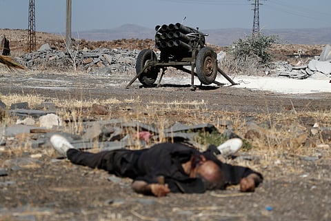 The body of a Druze militia member lies in front of a rocket launcher on the outskirts of Sweida city in southern Syria, Monday, July 14, 2025, where clashes erupted between Sunni Bedouin clans and the Druze militia.