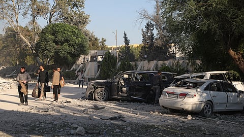 Security members carry belongings as they leave the damaged Syrian Defense Ministry building allegedly hit by several Israeli airstrikes, in Damascus, Syria, Wednesday, July 16, 2025.