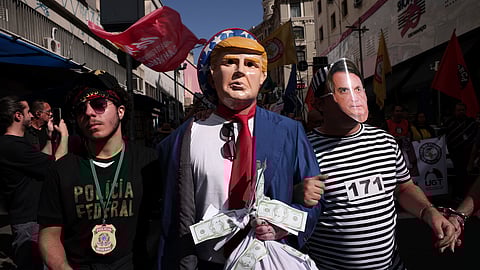 Protesters dressed as police escorting U.S. President Donald Trump and former president of Brazil Jair Bolsonaro demonstrate against Trump's announcement of 50% tariffs on Brazilian goods and against U.S. report that cited counterfeit product sales in Brazil, in Sao Paulo, Friday, July 18, 2025.