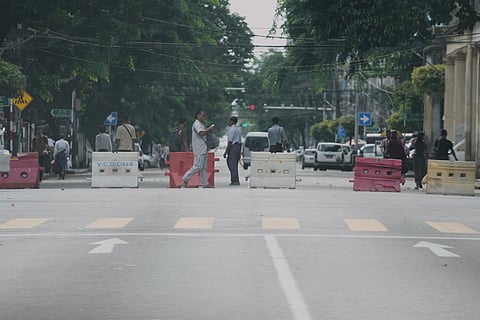 People walk past at a blocked road during the 78th anniversary of Martyrs' Day to mark the assassination of the country's independence heroes, including Gen. Aung San