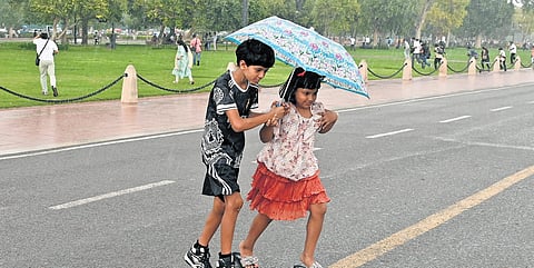 Children walk amid rainfall at India gate on Friday