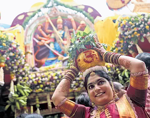 A woman carrying bonam arrives at the Lal Darwaza Sri Simhavahini Mahankali Devalayam.