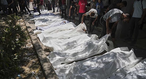 The bodies of Palestinians who were killed while attempting to access aid trucks entering northern Gaza through the Zikim crossing with Israel are brought to a clinic in Gaza City, Sunday, July 20, 2025.