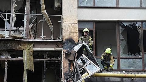 Firefighters work in a destroyed apartment building after a Russian attack in Kyiv, Ukraine, Monday, July 21, 2025.