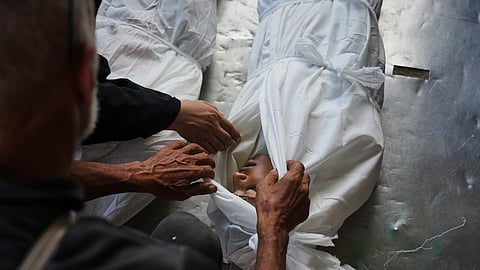 Relatives look at the body of Palestinian child Abdullah al-Rantisi, 11, killed by an Israeli military bombardment, in Deir al-Balah, central Gaza Strip, Monday, July 21, 2025