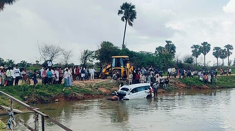 Authorities and passerby trying to recover the car.