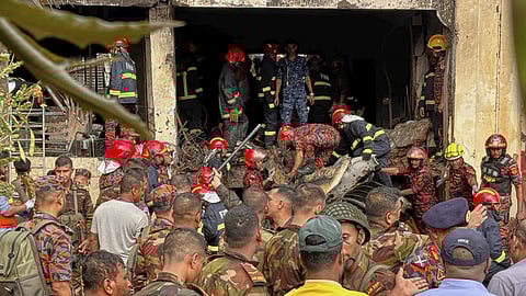 Firemen check the wreckage of a Bangladesh Air Force training aircraft that crashed onto a school campus in Dhaka, Bangladesh, Monday, July 21, 2025.