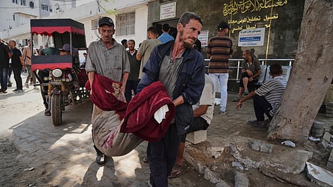 Palestinians carry the body of a person killed in an Israeli army airstrike on Gaza into Shifa Hospital in Gaza City on Tuesday, July 22, 2025.