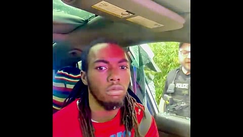 In this image made from cell phone video provided by the Law Office of Harry M. Daniels via TMX, William McNeil Jr. is seen sitting in his car after an officer broke his car window during a traffic stop on Feb. 19, 2025, in Jacksonville, Fla