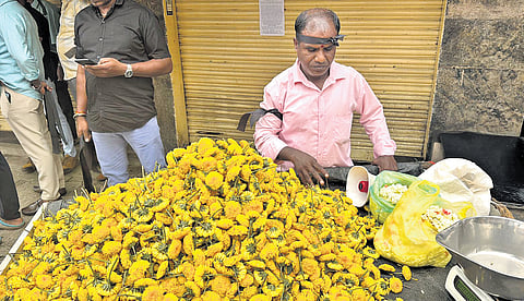 A flower vendor sports a black band to protest against GST notices, in Bengaluru on Wednesday.