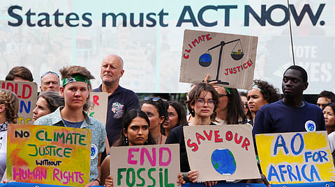 Activists demonstrate outside the International Court of Justice ahead of an advisory opinion on what legal obligations nations have to address climate change and what consequences they may face if they don't, Wednesday, July 23, 2025, in The Hague, Netherlands.