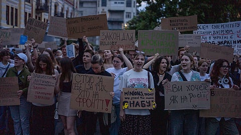 Protestors holding banners that read "I stand for you and for those who are on the frontline," "Do you want it like in Russia?" and "Stop robbing our future" during a protest against a law targeting anti-corruption institutions in central Kyiv, Ukraine, Tuesday, July 22, 2025.
