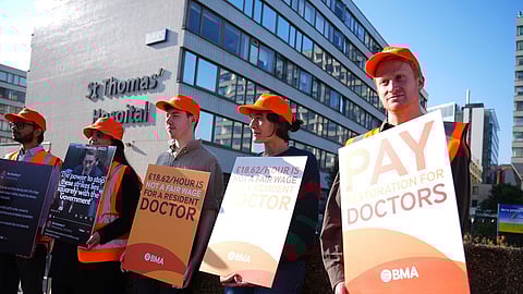 NHS resident doctors hold placards outside St Thomas' Hospital in London, as resident doctors in England, formerly referred to as junior doctors, begin a five-day strike after talks with the government collapsed over pay, Friday, July 25, 2025.
