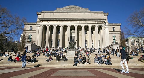 Students sit on the front steps of Low Memorial Library on the Columbia University campus in New York City, Feb. 10, 2023.