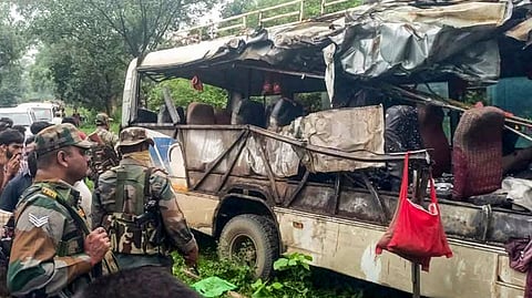 Security personnel and civilians gather near the wreckage of a vehicle after a collision took place between a bus with passengers on board and a truck, loaded with cooking gas cylinders, in Jharkhand's Deoghar district, Tuesday, July 29, 2025.