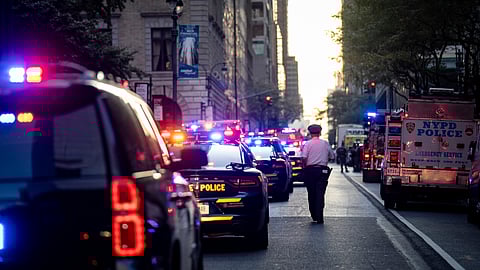A New York police officer stands watch on 52nd Street outside a Manhattan office building where at least two people were shot, including a police officer, Monday, July 28, 2025, in New York.