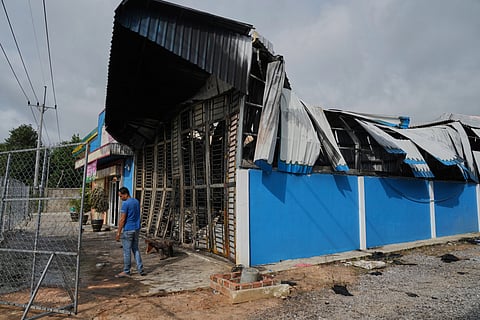 A man stands next to a damaged gas station in Phrong village, Oddar Meanchey province, Cambodia, Wednesday, July 30, 2025, after a ceasefire to end deadly border clashes was reached between Thailand and Cambodia.
