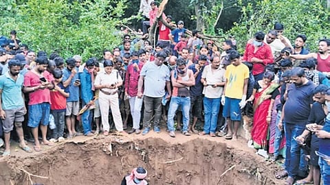 People gather at the backyard as the bodies are being exhumed by police.