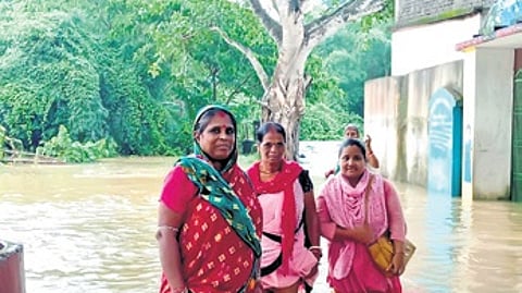 Women wading through the floodwater in a village in Kendrapara on Tuesday.