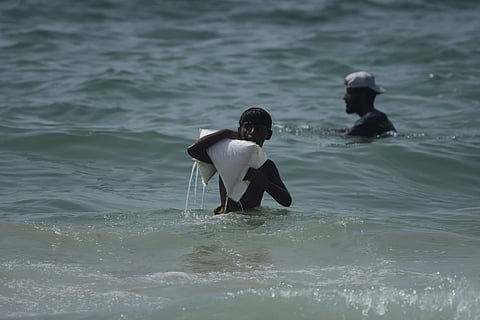 A Palestinian youth carries a sack of aid that landed in the Mediterranean Sea after being airdropped over central Gaza, at the shore of Zawaida, Gaza Strip Tuesday, July 29, 2025.