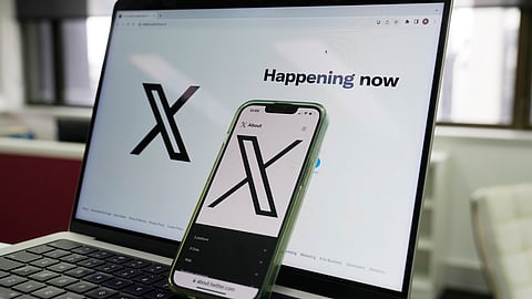 The opening page of X is displayed on a computer and phone in Sydney on Oct. 16, 2023.