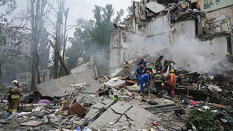Rescuers work in a destroyed apartment building after a Russian missile attack in Kyiv, Ukraine, Thursday, July 31, 2025