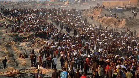 People carrying sacks of flour walk along al-Rashid street in western Jabalia on June 17, 2025