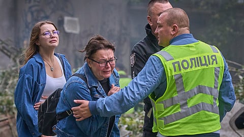Women react outside a destroyed apartment building after a Russian missile attack in Kyiv, Ukraine, Thursday, July 31, 2025