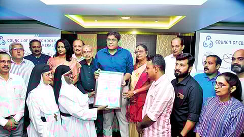 Director of General Education N S K Umesh handing over an aid of C10 lakh to manager of Mount Tabor English School, Meppadi, Sr Salomi, at an event in Kochi.