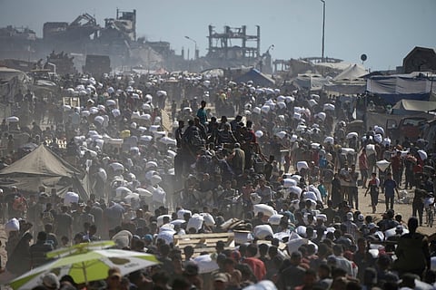 Palestinians carry sacks of flour taken from a humanitarian aid convoy en route to Gaza City, in the outskirts of Beit Lahiya, northern Gaza Strip, Friday, Aug. 1, 2025