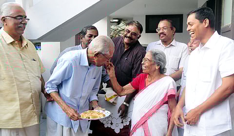 N Ratnamma, wife of writer and critic M K Sanoo, giving sweets to M K Sanoo on his 90th birthday.