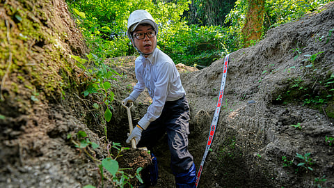 Rebun Kayo, a Hiroshima University researcher, searches for remains of victims of the 1945 Hiroshima bombing in Ninoshima in Hiroshima, western Japan, Tuesday, July 8, 2025