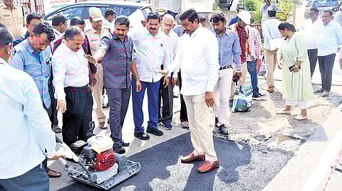 R&B Minister BC Janardhan Reddy inspecting road repairs with steel slag.