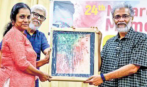 At the 24th N. Narendran Memorial Lecture held in Thiruvananthapuram, Reema Narendran presents a memento to Deepankar Bhattacharya, General Secretary of CPI(ML) Liberation. N. Madhavankutty is also present nearby.