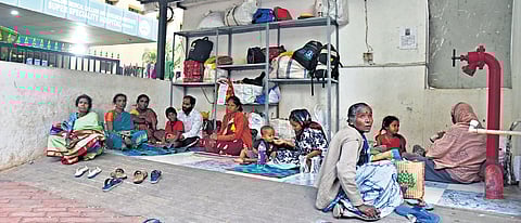 Attendants of patients admitted to Victoria Hospital take shelter at trolley bay.