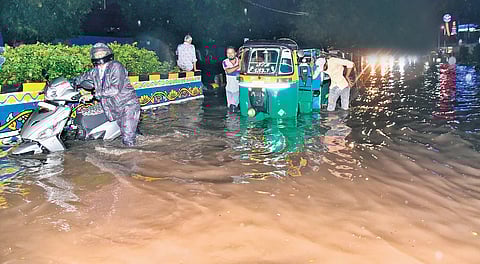 Commuters forced to push their vehicles that were stranded on the flooded Raj Bhavan Road in Hyderabad on Thursday.