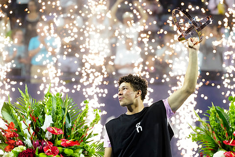Ben Shelton, of the United States, lifts the trophy as he celebrates after his win over Karen Khachanov, of Russia, in the final match at the National Bank Open men's tennis tournament in Toronto, Thursday, Aug. 7, 2025.
