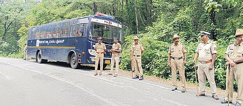 Police stand guard at site no. 15 at Boliyar during the exhumation on Friday.