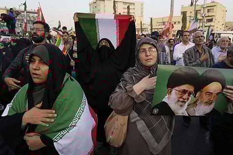Iranian protesters hold their country’s flags and a poster of Supreme Leader Ayatollah Ali Khamenei, left, and the late revolutionary founder Ayatollah Khomeini in an anti-U.S. and anti-Israeli rally at Enqelab-e-Eslami (Islamic Revolution) square in downtown Tehran, Iran, Tuesday, June 24, 2025.