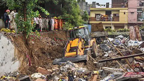 Debris being removed from the site after a wall collapsed amid heavy rains, near Mohan Baba Mandir at Harinagar, in Delhi's Jaitpur, Saturday, Aug. 9, 2025.