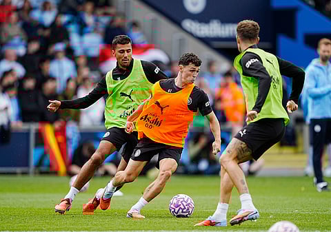 Manchester City's Phil Foden, center, and Rodri during a training session at the City Football Academy, Manchester, England, Tuesday, Aug. 5, 2025.