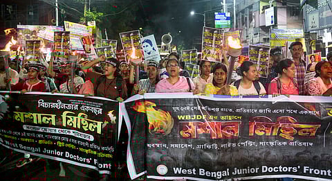 Junior Doctors' Forum members, senior doctors and others raise slogans during a torch rally from College Street to Shyambazar on the eve of first death anniversary of the rape-murder of a trainee doctor of RG Kar Medical College and Hospital, in Kolkata, West Bengal, Friday, Aug. 8, 2025.