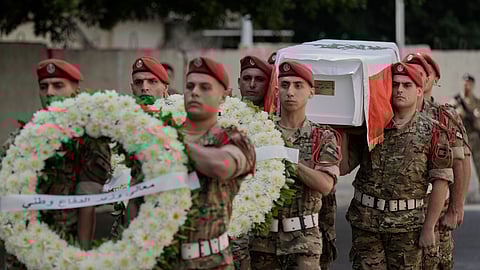 Lebanese army soldiers carry the coffin of Mohammad Shuqair, wrapped in the national flag, during his funeral procession at the Lebanese Military Hospital in Beirut, Lebanon, Sunday, Aug. 10, 2025.