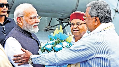 Prime Minister Narendra Modi being received by Karnataka CM Siddaramaiah and Governor Thaawarchand Gehlot in Bengaluru on Sunday