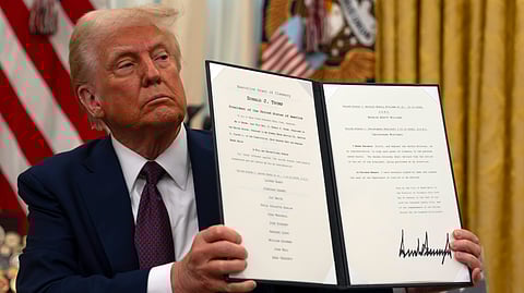 President Donald Trump holds up a signed executive order relating to clemency for anti-abortion protesters as he signs executive orders in the Oval Office of the White House.