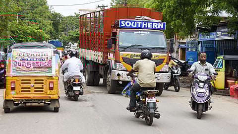 Heavy vehicles ply in peak hours on busy Gandhi Market Road in Tiruchy.